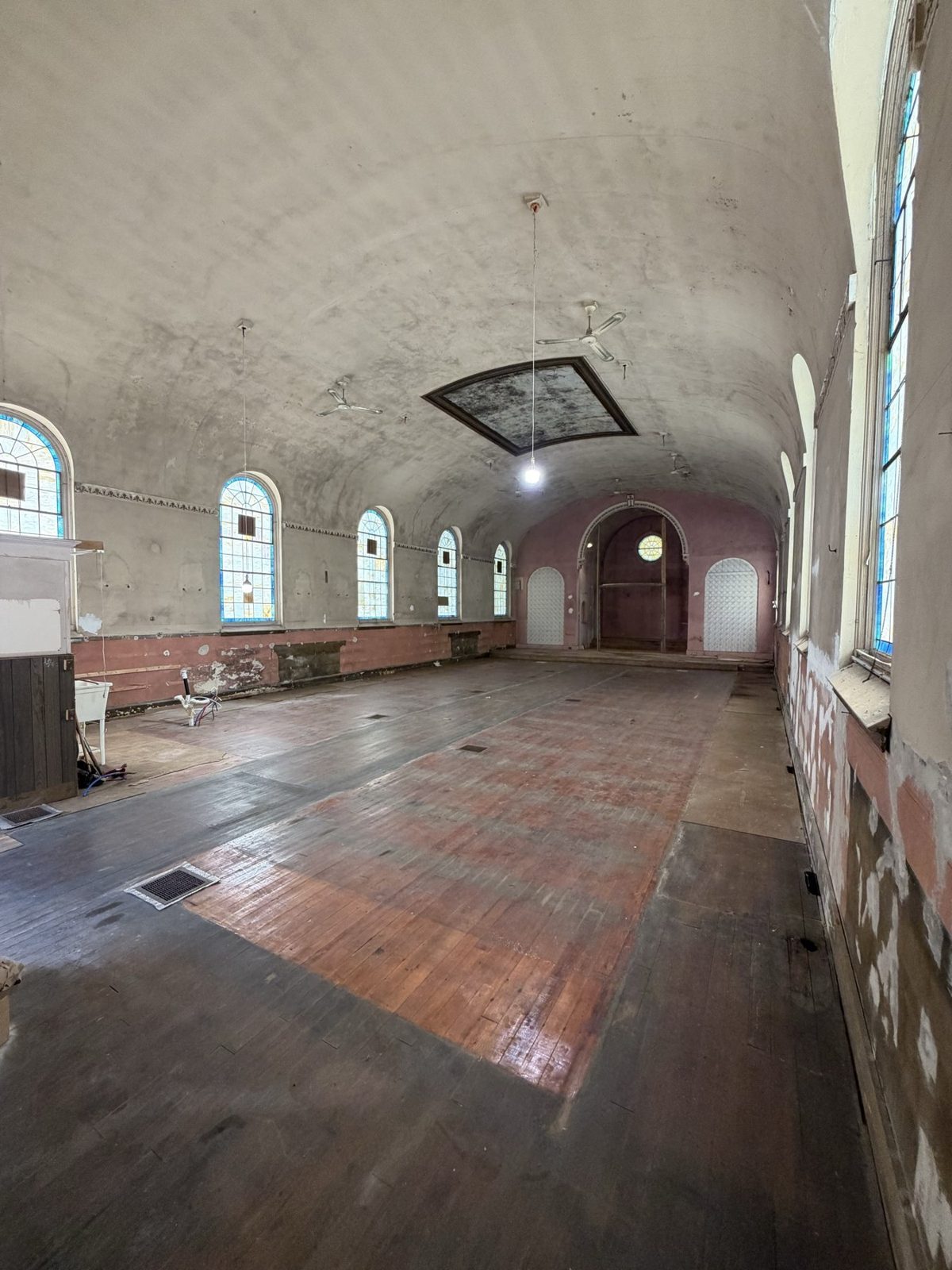 The main hall with barrel vault, arched windows and wooden floor